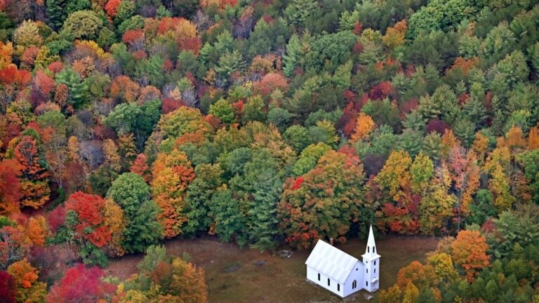 Fall foliage surrounds a small church near East Parsonsfield, Maine.