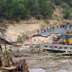 Crews work to clear debris from the Cade Loop bridge along the Guadalupe River.