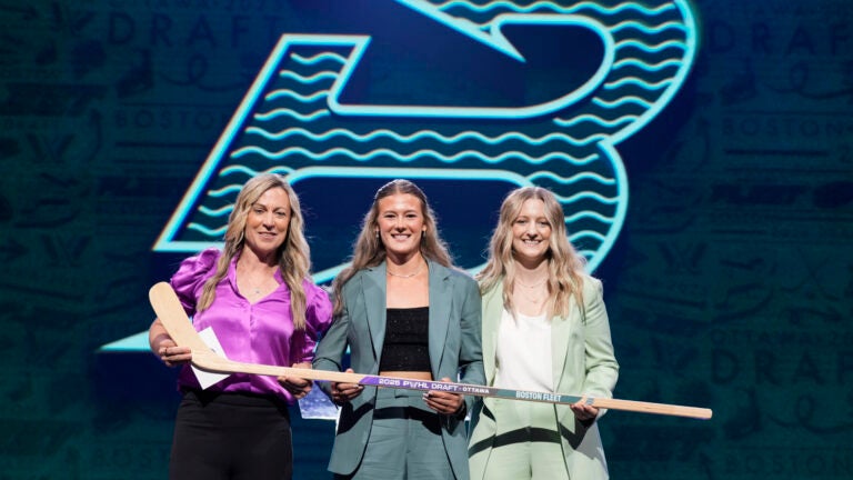 Haley Winn, center, poses for a photo after the Boston Fleet selected her during the first round of the PWHL draft in Ottawa, Ontario, Tuesday, June 24, 2025.