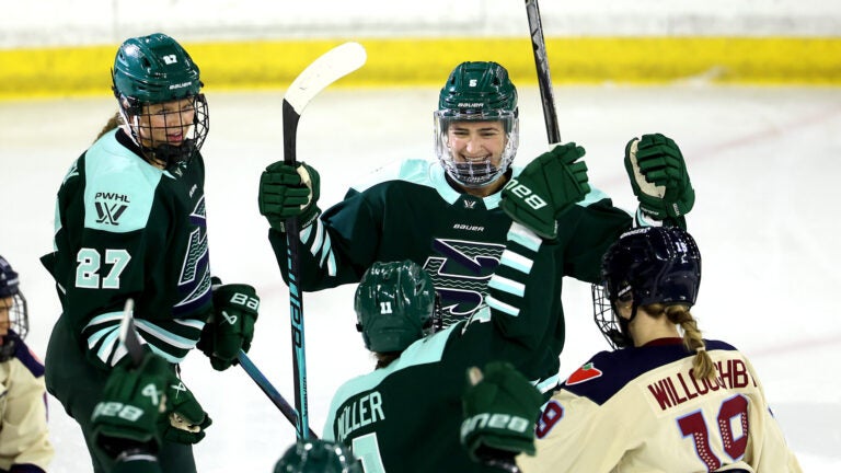 Fleet team captain Megan Keller, top right, celebrates her second period goal with teammates Shay Maloney, left, and Alina Müller during the season opener against Montreal at Tsongas Center on Sunday, November 23, 2025.